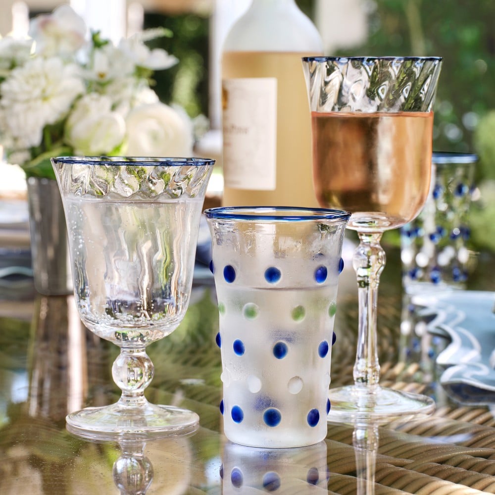 clear glass with blue dots and bottle of wine