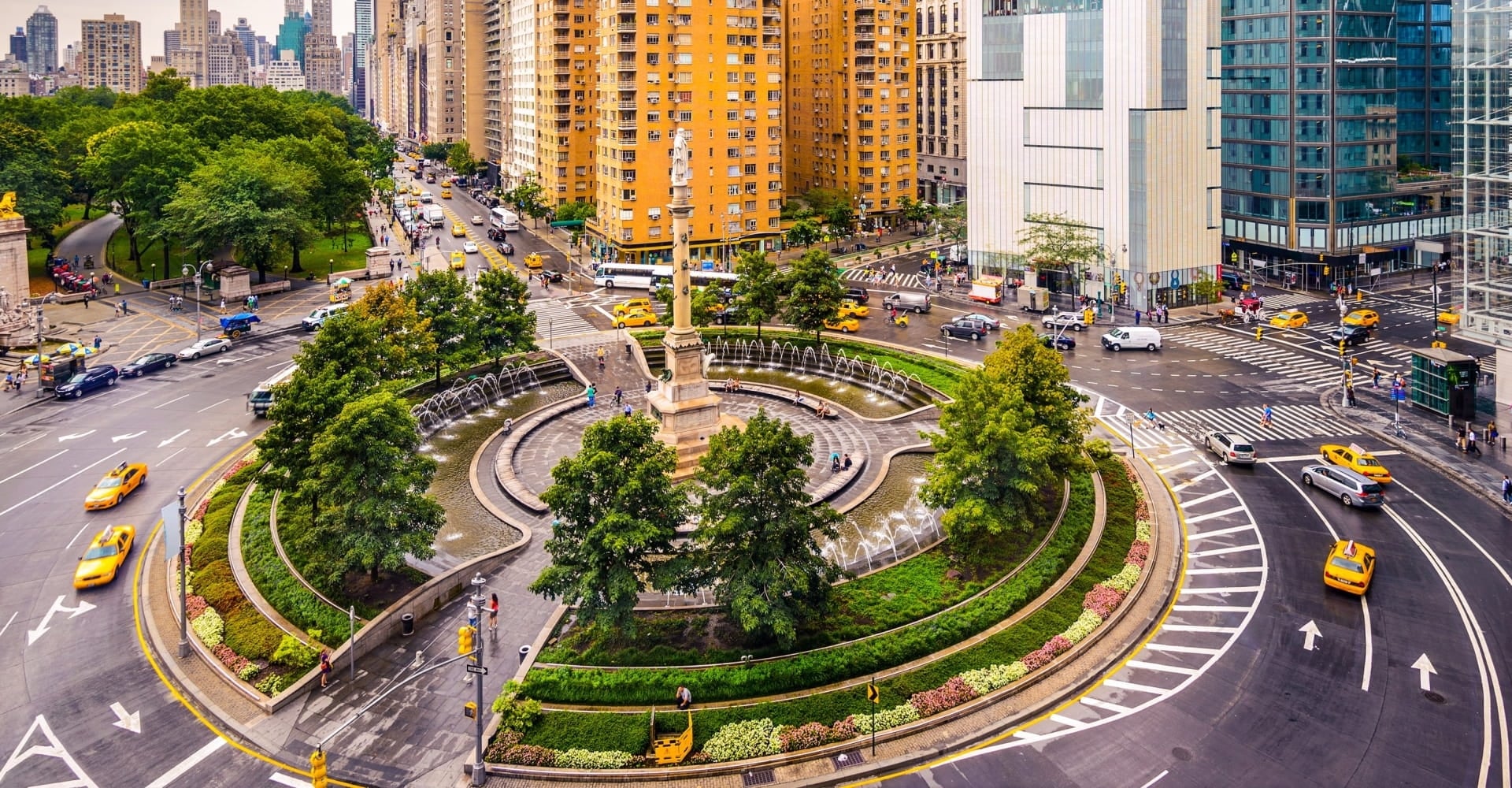 columbus circle, taxi and cars driving around during day