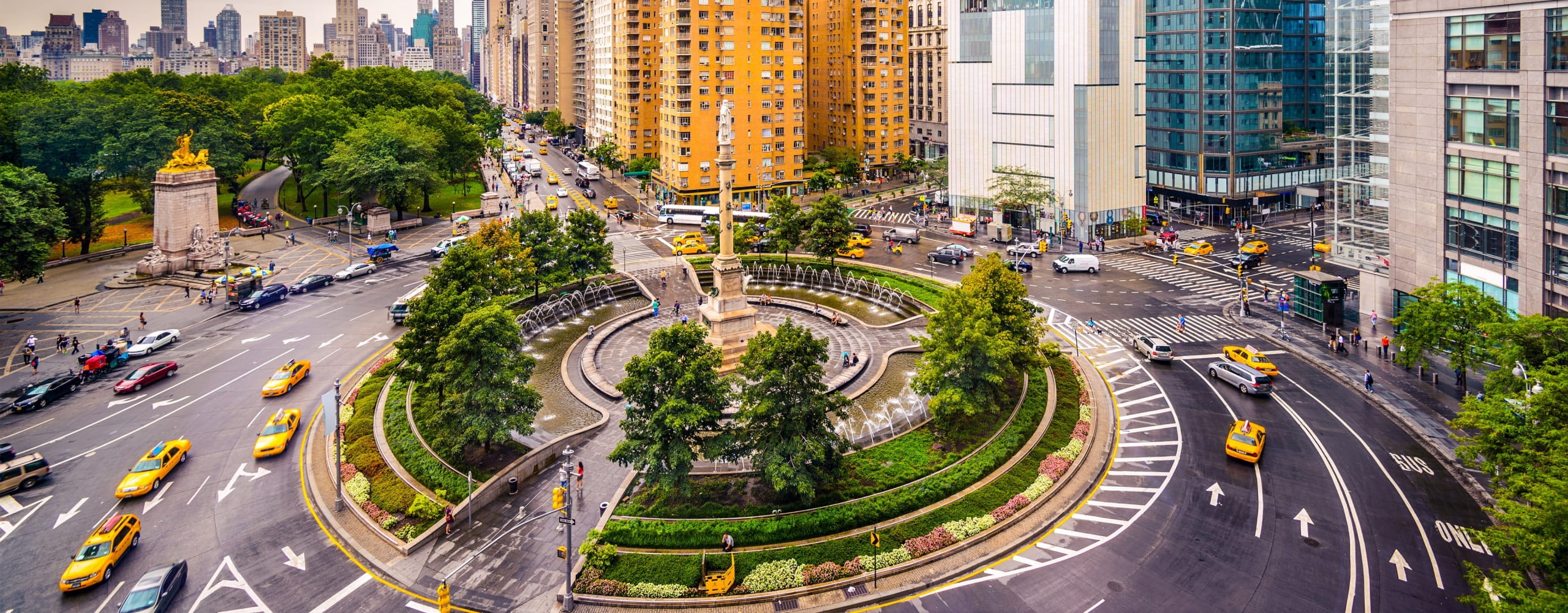 columbus circle, taxi and cars driving around during day