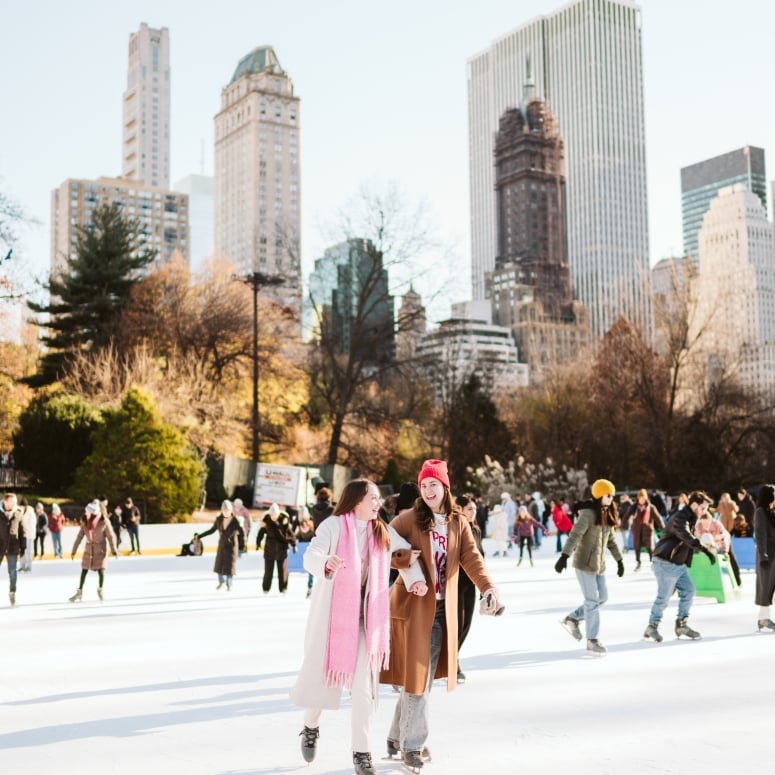 two friends skating on the ice in columbus circle